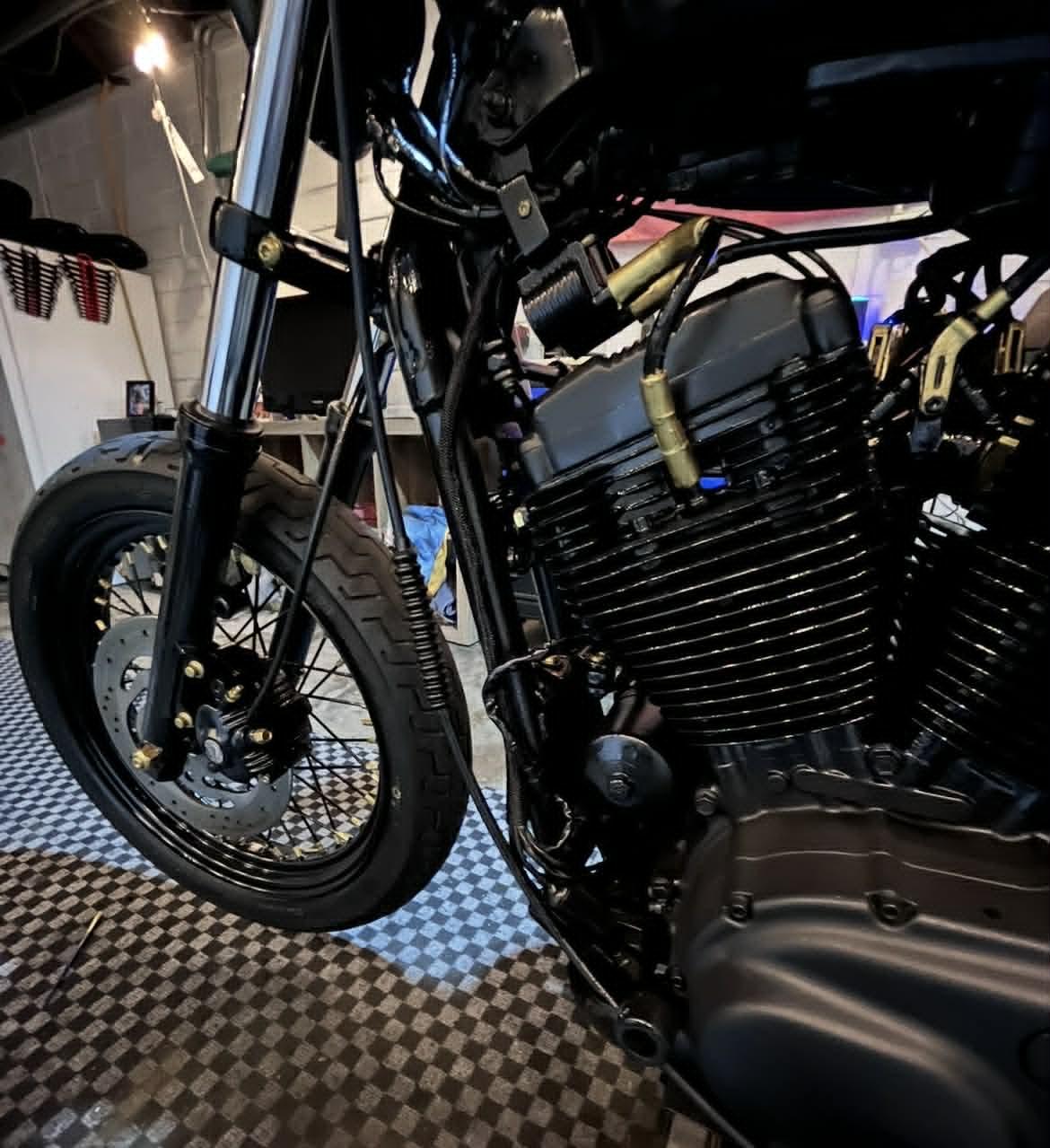V-twin engine close-up — fresh black paint with gold pushrod tubes and gold accents